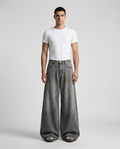 Maxout Jeans Charcoal Fade on model — mega baggy fit covering sneakers