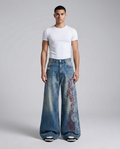 Slack Embroidered Jeans Wildfire Fade on model — mega baggy fit covering sneakers